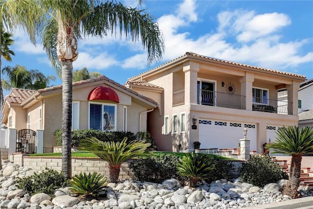 mediterranean / spanish-style house with a tiled roof, a balcony, an attached garage, and stucco siding