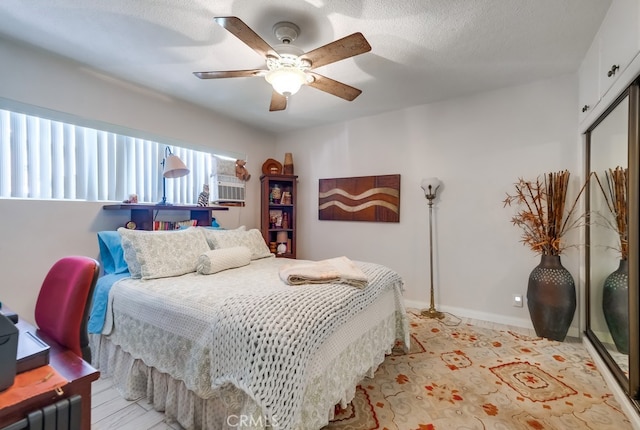 bedroom featuring baseboards, a textured ceiling, and a ceiling fan