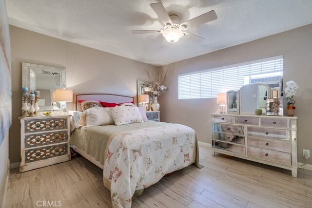 bedroom featuring baseboards, light wood-style floors, and ceiling fan
