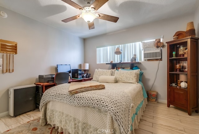 bedroom with cooling unit, baseboards, ceiling fan, and wood finished floors