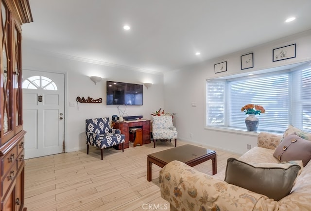 living area with baseboards, ornamental molding, recessed lighting, and light wood-style floors