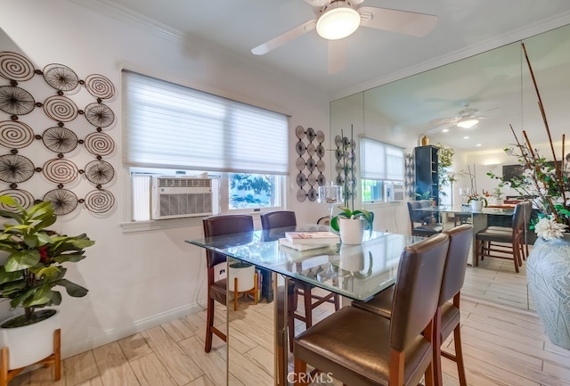 dining space featuring light wood-type flooring, baseboards, a ceiling fan, and crown molding