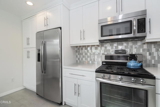 kitchen featuring light tile patterned floors, decorative backsplash, stainless steel appliances, light countertops, and white cabinetry