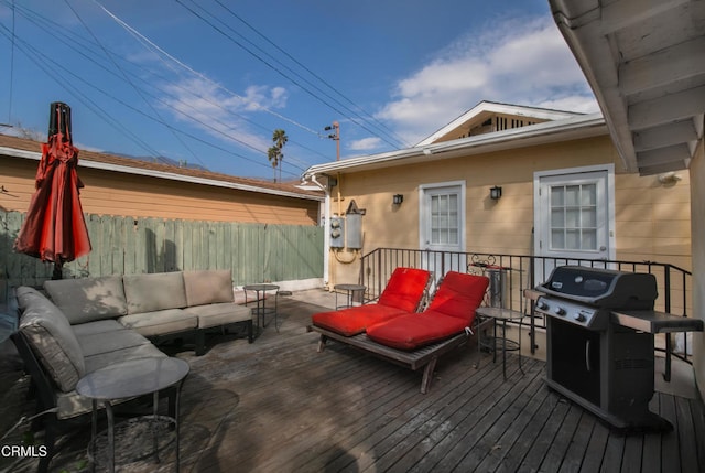 deck with a grill, fence, and an outdoor hangout area