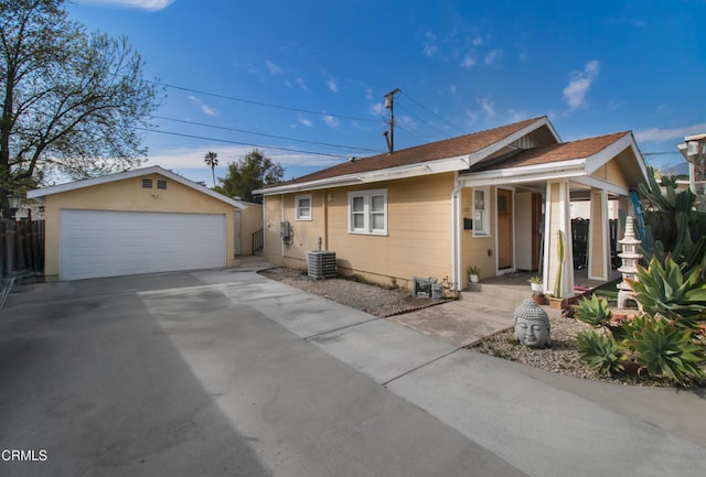 view of front of house featuring a garage, cooling unit, and an outdoor structure