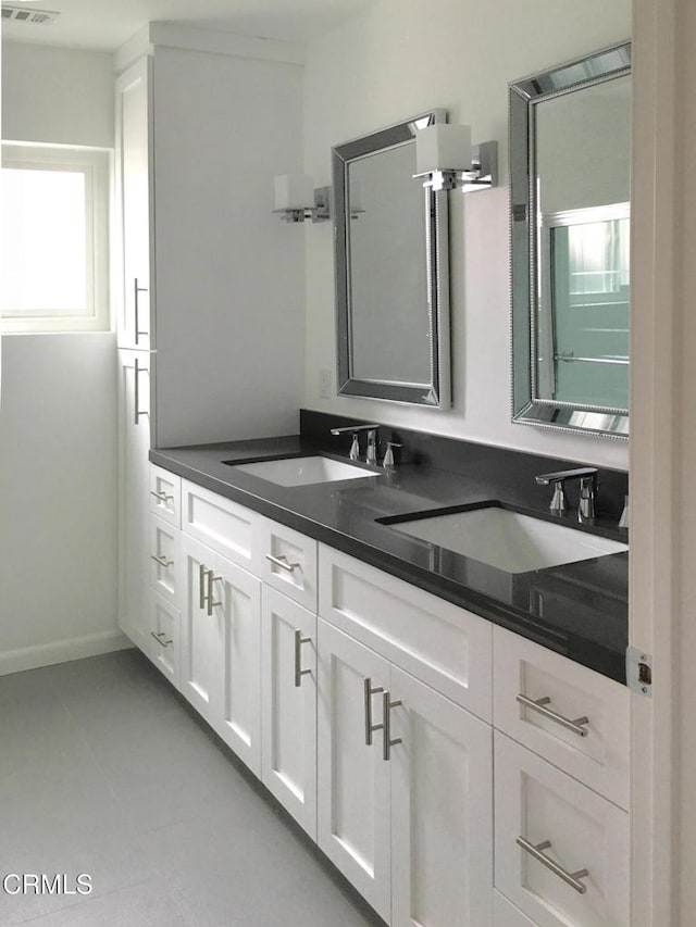 full bathroom with double vanity and a sink