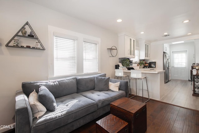 living room featuring visible vents, dark wood finished floors, and recessed lighting