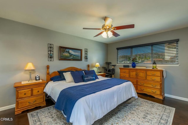 bedroom with a ceiling fan, baseboards, and dark wood-type flooring