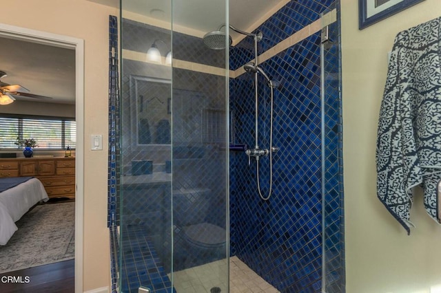 bathroom featuring ensuite bathroom, tiled shower, a sink, and a ceiling fan