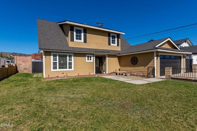 exterior space featuring a lawn, an attached garage, and fence