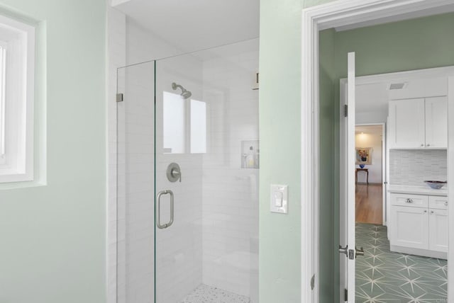 bathroom featuring a shower stall, visible vents, tasteful backsplash, and vanity