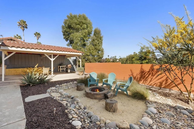 view of yard featuring fence, a fire pit, and a patio