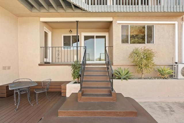 doorway to property featuring ac unit and stucco siding