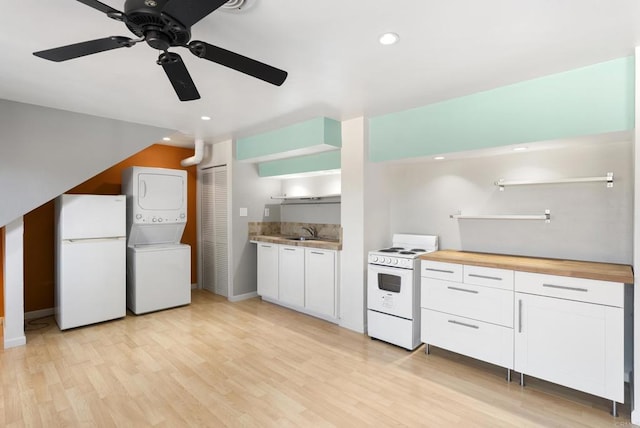 kitchen with white appliances, stacked washer and clothes dryer, white cabinetry, open shelves, and a sink