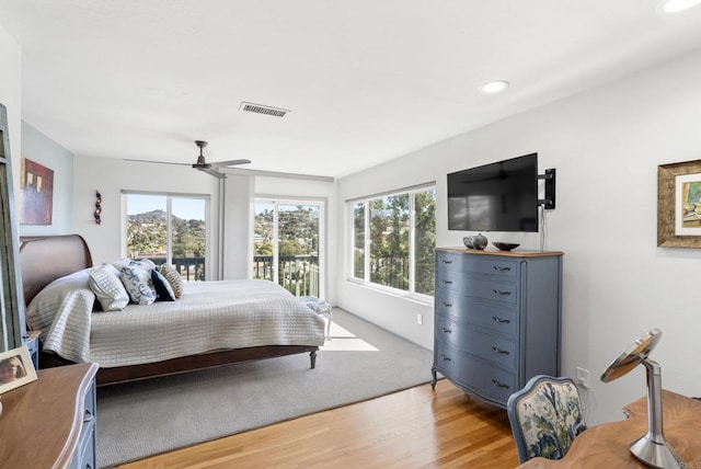 bedroom with ceiling fan, multiple windows, light wood-type flooring, and visible vents