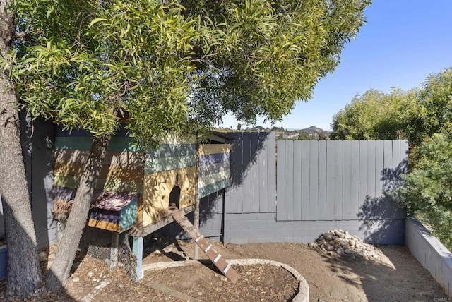 view of home's exterior with fence and concrete block siding