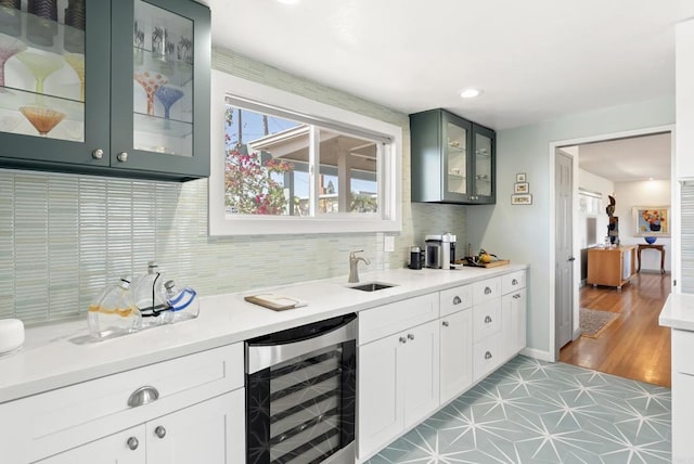 bar featuring decorative backsplash, wine cooler, a sink, and recessed lighting