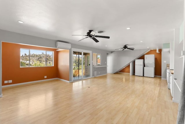 unfurnished living room with ceiling fan, recessed lighting, stacked washer and dryer, and plenty of natural light