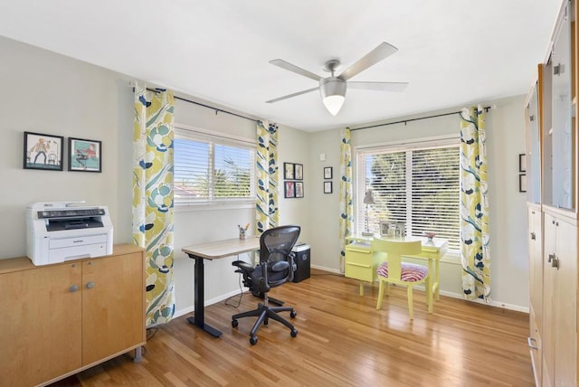office space featuring light wood finished floors, a ceiling fan, and baseboards