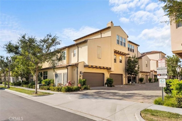 view of front of home with a garage, driveway, and stucco siding