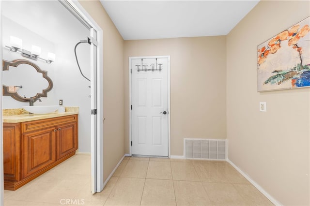 interior space featuring tile patterned flooring, visible vents, vanity, and baseboards