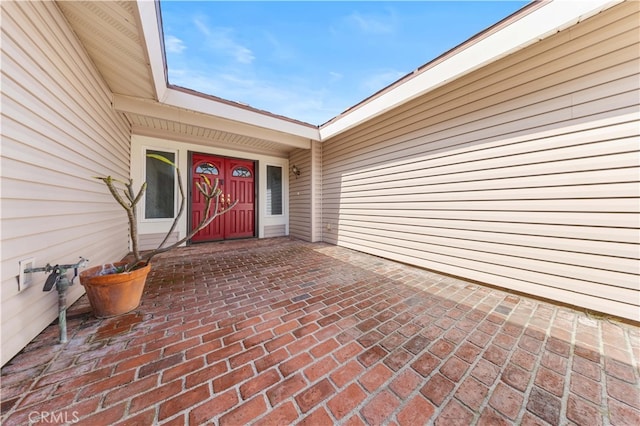 view of exterior entry featuring a patio area