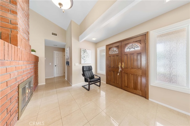 entrance foyer with lofted ceiling, light tile patterned floors, baseboards, and visible vents