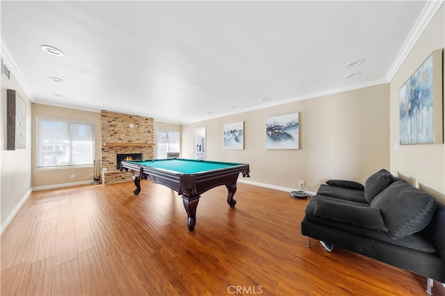 recreation room with pool table, wood finished floors, baseboards, ornamental molding, and a brick fireplace