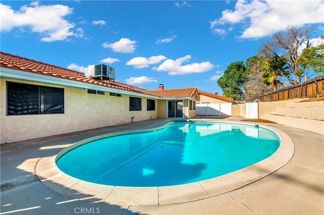 view of pool featuring a patio, a fenced backyard, a fenced in pool, and central air condition unit