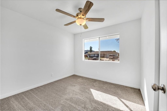 empty room featuring carpet floors, ceiling fan, and baseboards