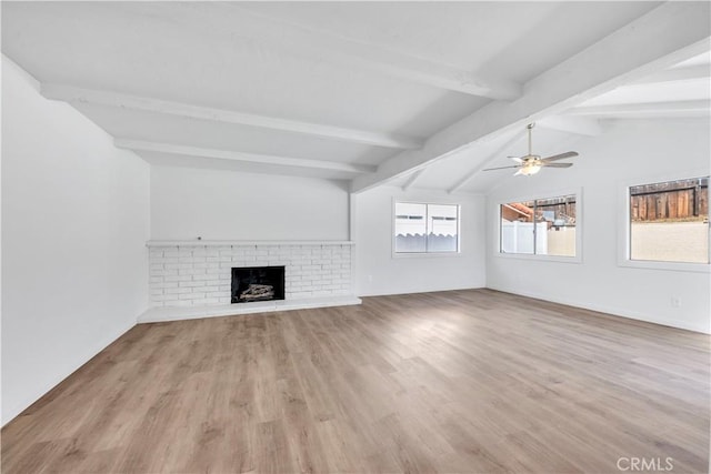 unfurnished living room with vaulted ceiling with beams, a brick fireplace, light wood finished floors, and a ceiling fan