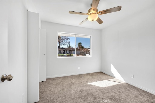 unfurnished bedroom featuring light carpet, baseboards, and a ceiling fan