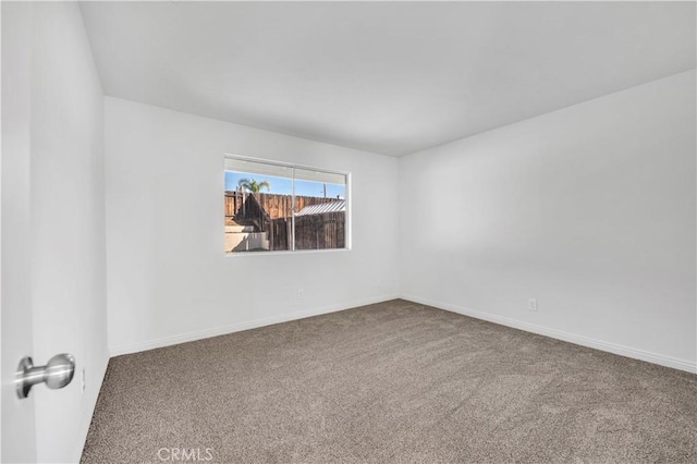 carpeted empty room with baseboards