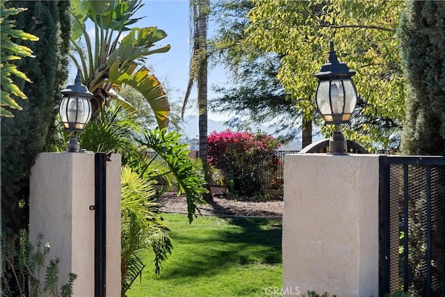 view of gate featuring fence and a lawn