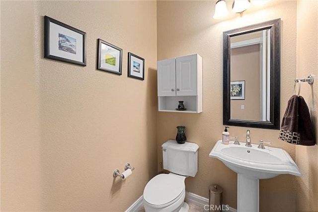 half bath with toilet and baseboards