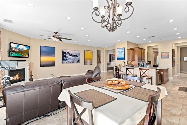 dining room featuring light tile patterned flooring, recessed lighting, visible vents, baseboards, and a glass covered fireplace