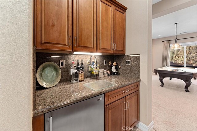 bar featuring carpet flooring, a sink, hanging light fixtures, dishwasher, and tasteful backsplash