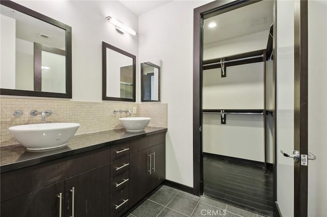 full bathroom featuring tile patterned flooring, a sink, visible vents, and tasteful backsplash
