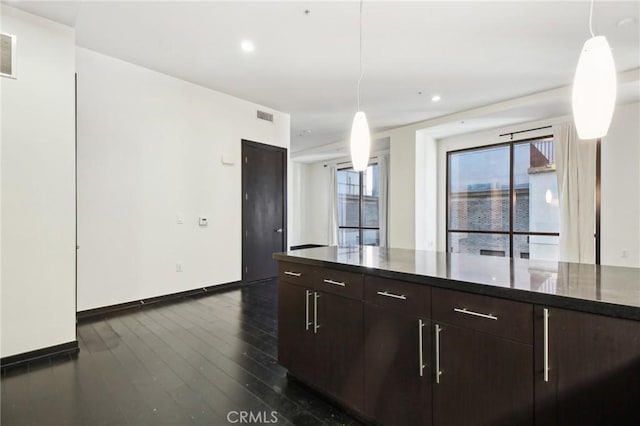 kitchen with dark wood-style flooring, dark brown cabinets, baseboards, and visible vents