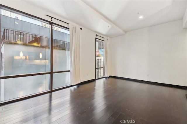 spare room with wood finished floors and baseboards