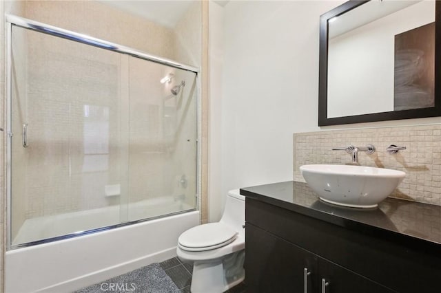 full bath featuring vanity, tile patterned floors, combined bath / shower with glass door, and toilet