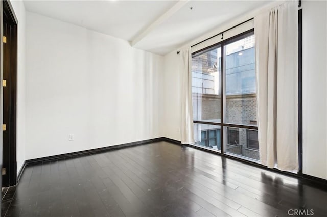 unfurnished room featuring baseboards and wood finished floors