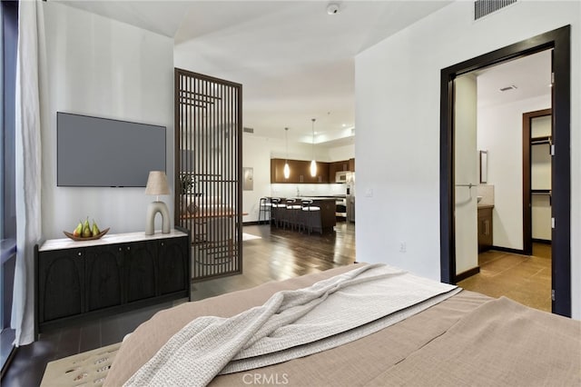 bedroom with visible vents, baseboards, and wood finished floors