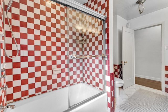 bathroom with toilet, enclosed tub / shower combo, and tile patterned floors