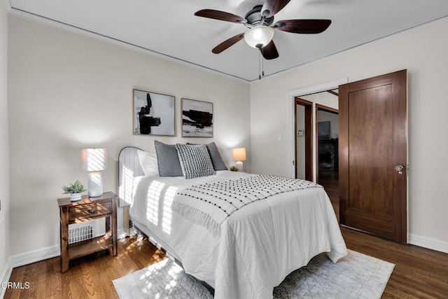 bedroom featuring dark wood-style floors, baseboards, a ceiling fan, and ornamental molding