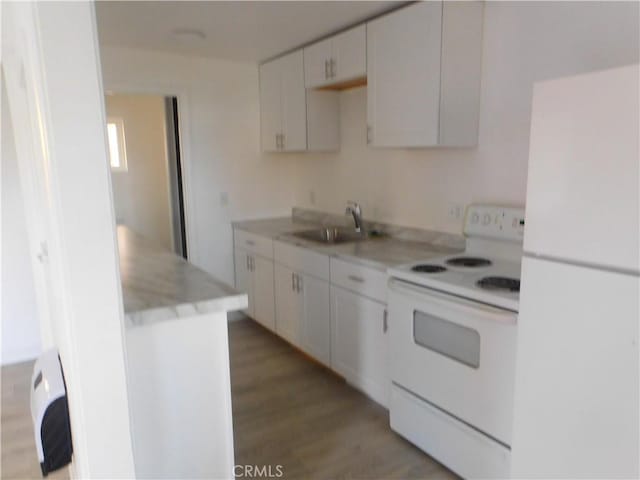 kitchen featuring light countertops, light wood-style flooring, white cabinetry, a sink, and white appliances