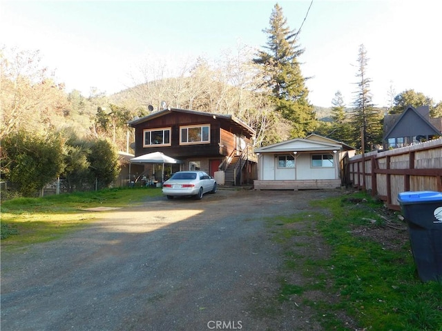 view of front of property with driveway, fence, and a mountain view