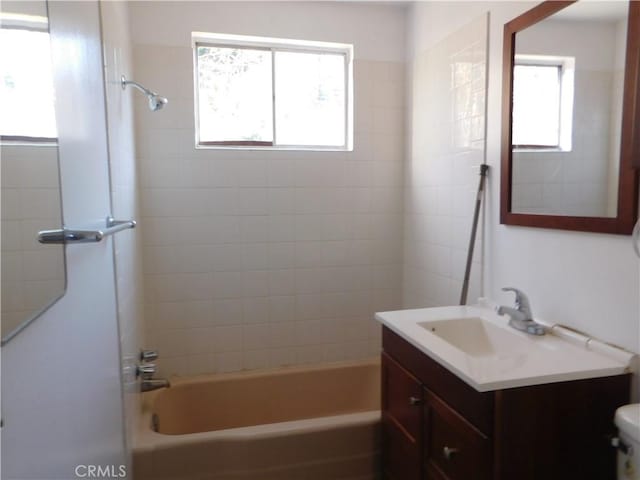 full bathroom with toilet, washtub / shower combination, a wealth of natural light, and vanity