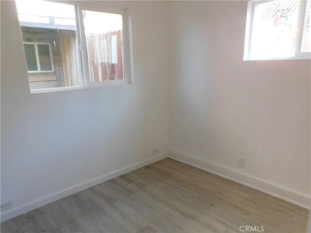 unfurnished room with wood finished floors and baseboards