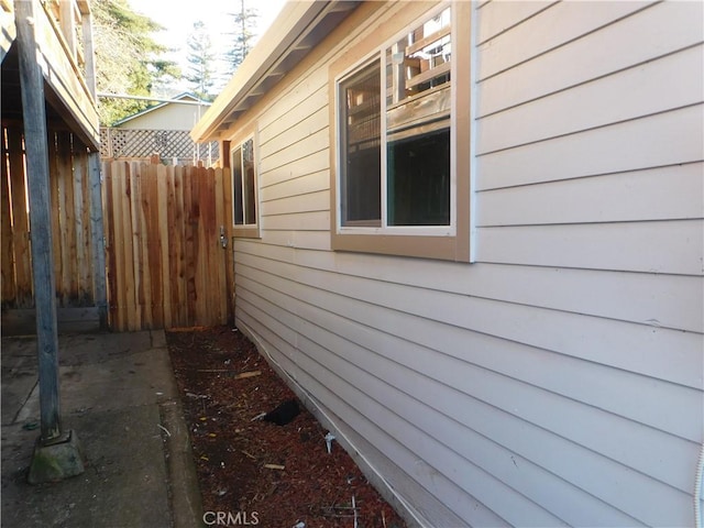 view of side of home featuring fence